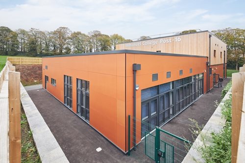 Modern skolutbyggnad med Hardie® Architectural Panel Metallics Koppar